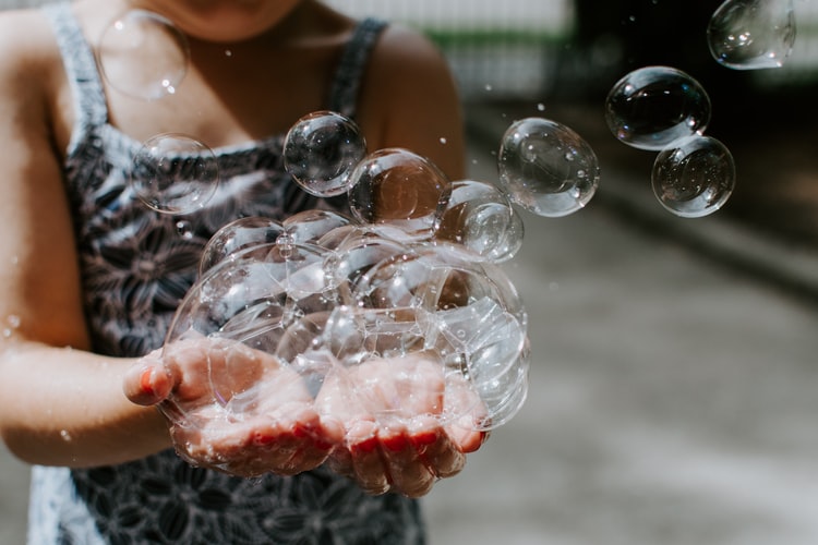 Egaliki : Offrir la même égalité des chances à la naissance pour révéler le talent des enfants- enfants qui tient des bulles de savon dans ses mains- Photo by Kelly Sikkema on Unsplash