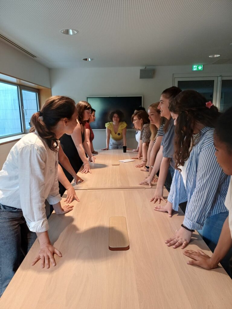 Photo de l'atelier animé en non mixité Mesdames, prenez votre place ! animé à la Nantes Digital Week. Des femmes testent une posture autour de la table